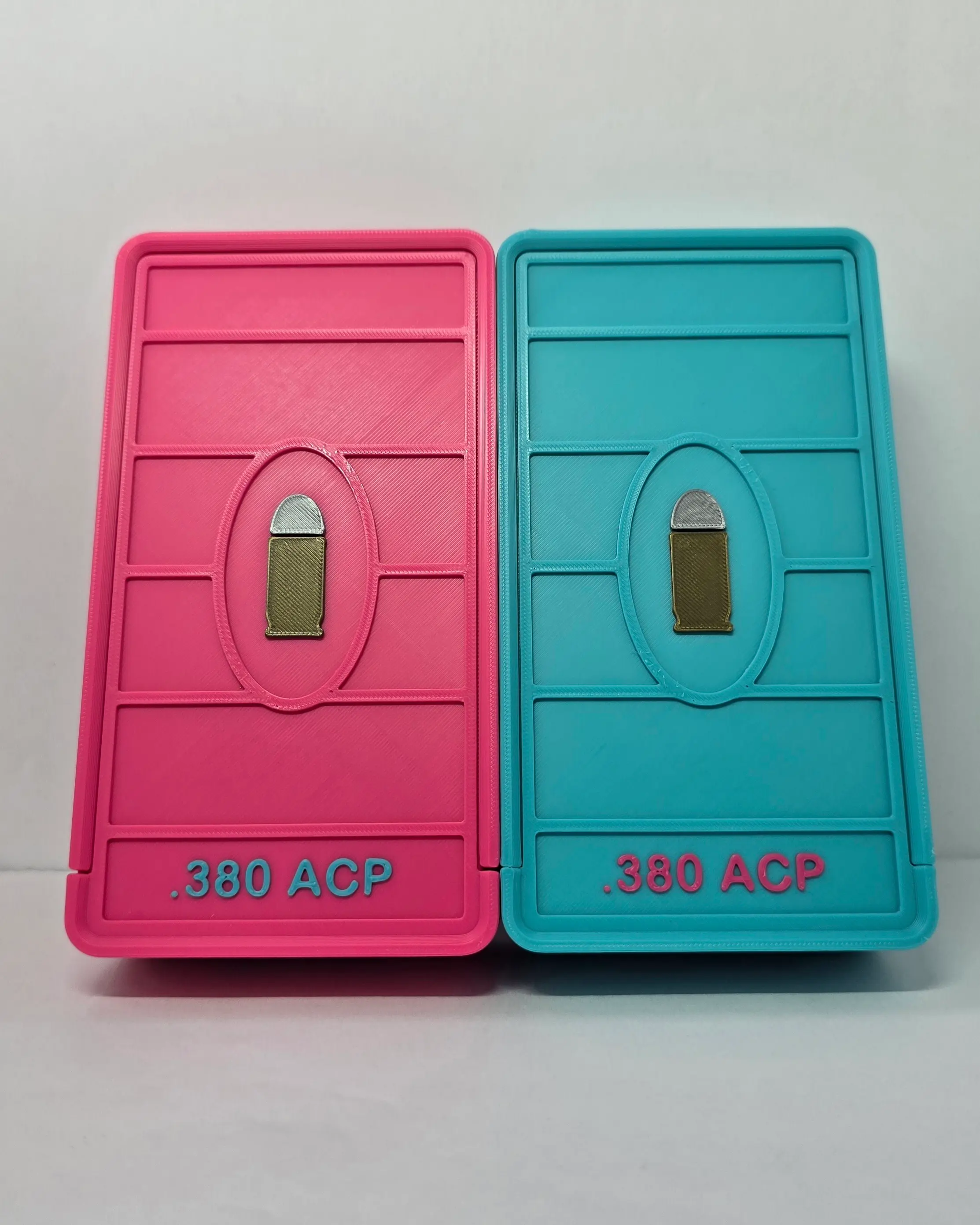 Top view of custom .380 ACP ammo box lids in Hot Pink and Turquoise